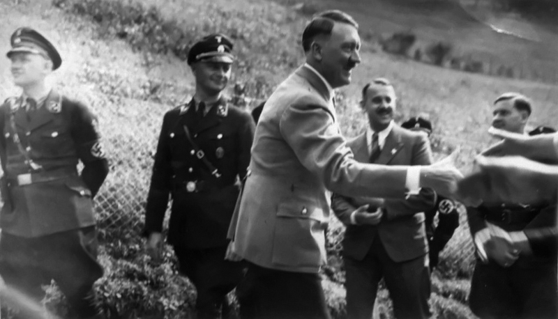 Adolf Hitler greets people outside of Haus Wachenfeld during one of the many times visitors could come and see him on the Obersalzberg